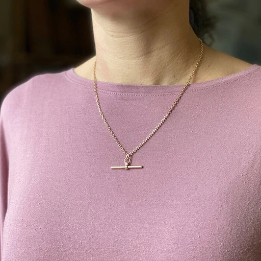 Gold t on sale bar necklace meaning